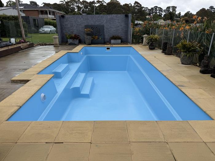 Rectangular pool with corner steps finished in light blue