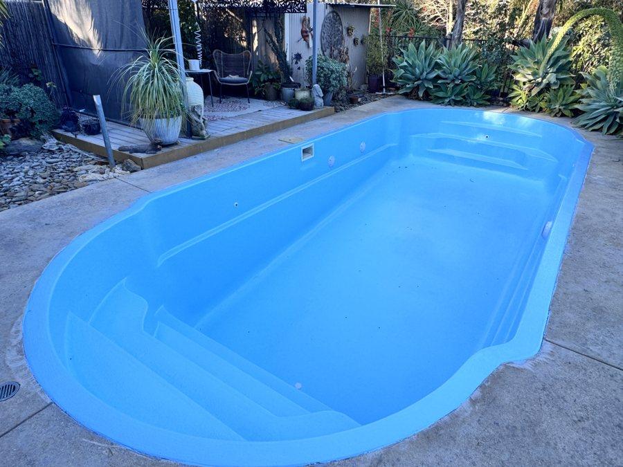 Freeform pool with steps resurfaced in light blue