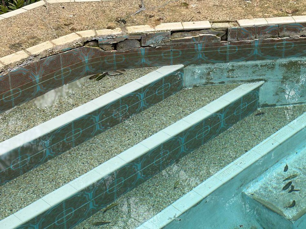 Worn pebblecrete steps with tile band, before resurfacing